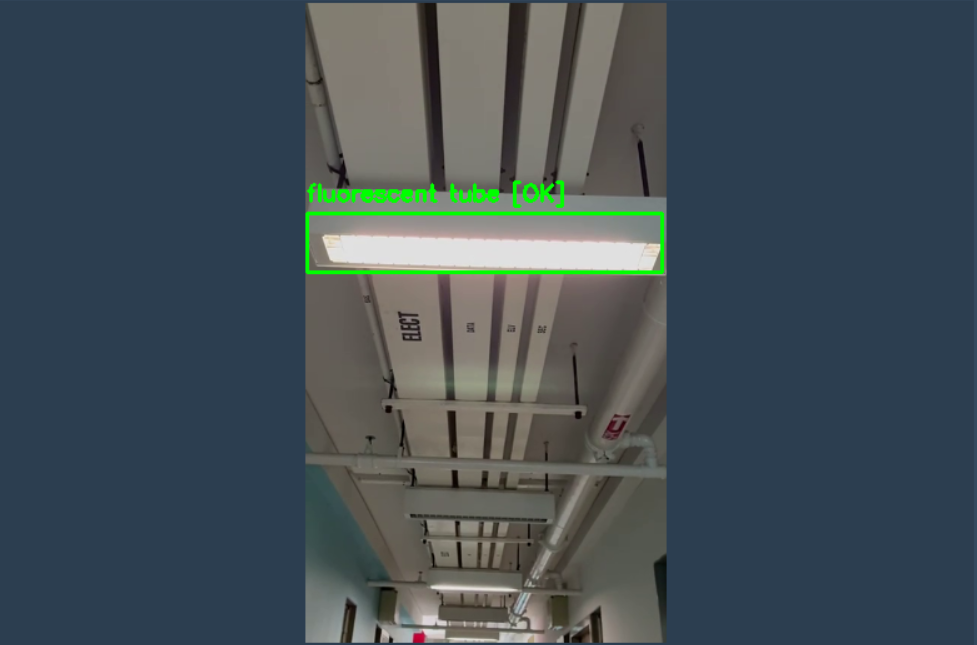 Camera feed showing fluorescent tube in corridor ceiling with green bounding box labelled OK